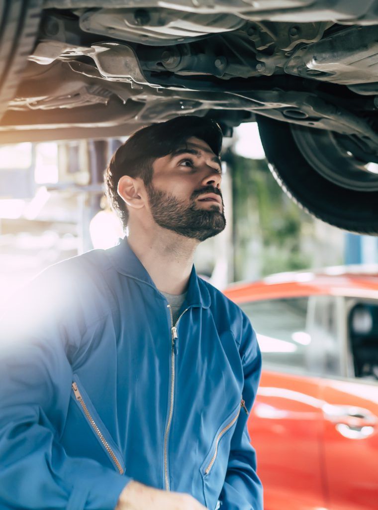 Mechanic inspecting underneath a vehicle - MOT Testing West Bromwich