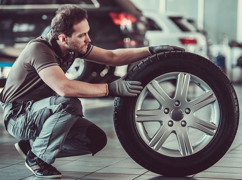 Mechanic looking over a new tyre - Tyres West Bromwich